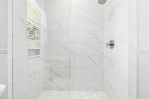 a bathroom with a sink toilet a mirror and shower
