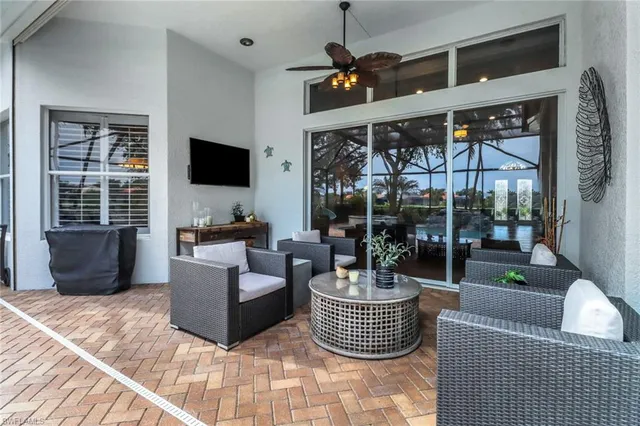 a living room with furniture a flat screen tv and a large window