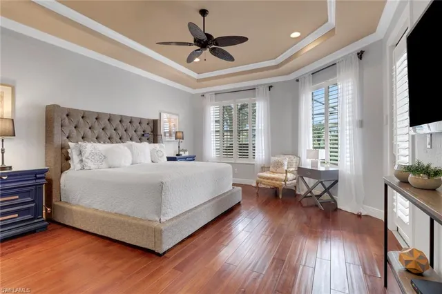 a bedroom with a bed couch and a flat tv screen on a dresser