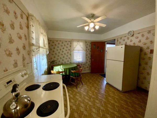 a kitchen with a refrigerator and a stove top oven