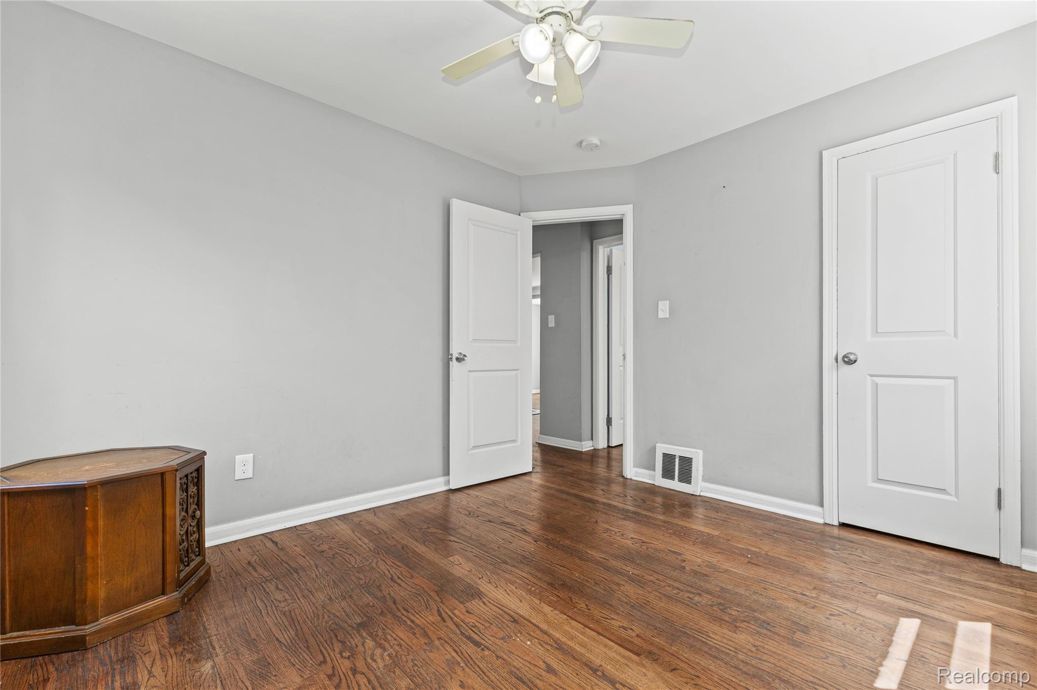 26508 Five Mile Road Redford, MI 48239 - Photo 24 of 41 Room featuring wood-finish flooring, light gray walls, white trim, and a ceiling fan