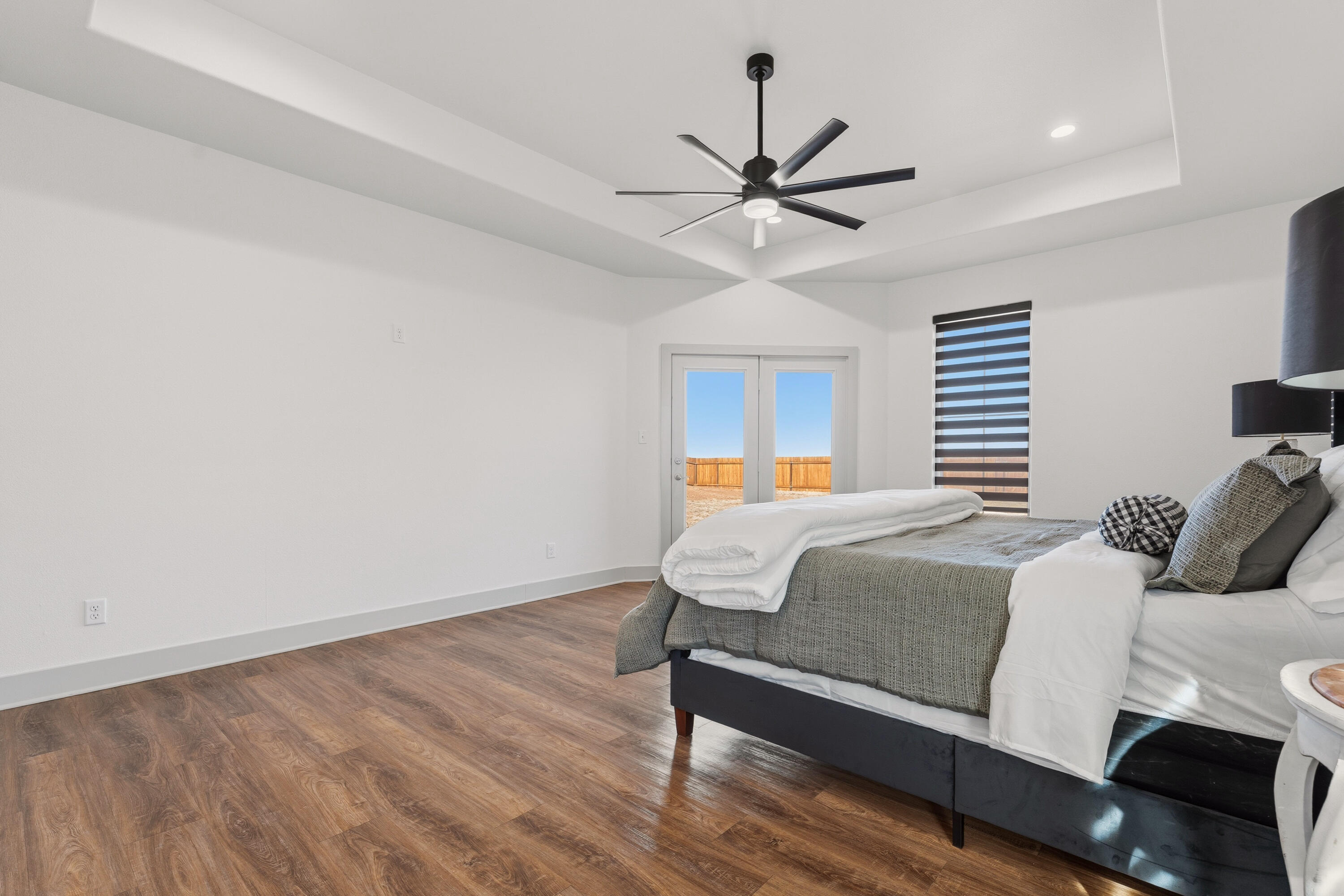 19215 County Road 2240 Lubbock, TX 79423 - Photo 15 of 36 a bedroom with a bed and a chandelier