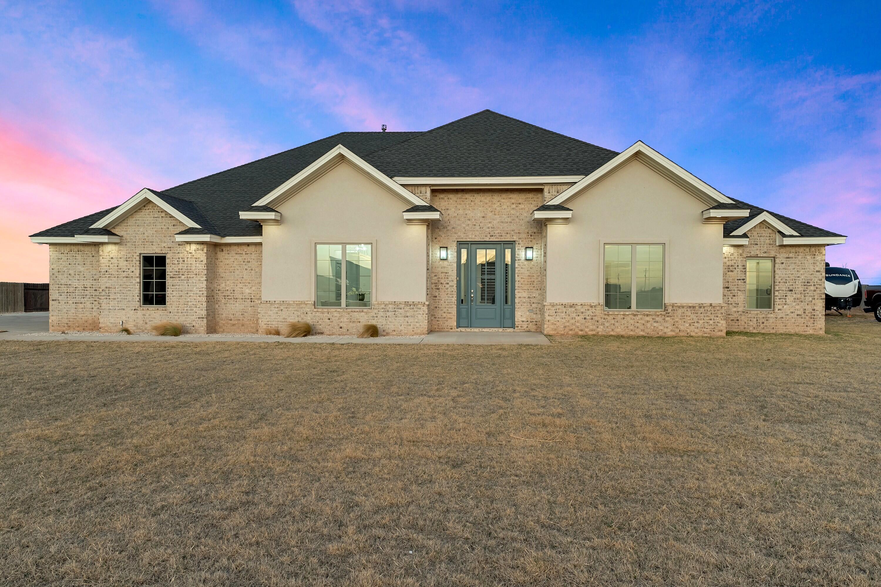 19215 County Road 2240 Lubbock, TX 79423 - Photo 2 of 36 a front view of a house with a yard and garage