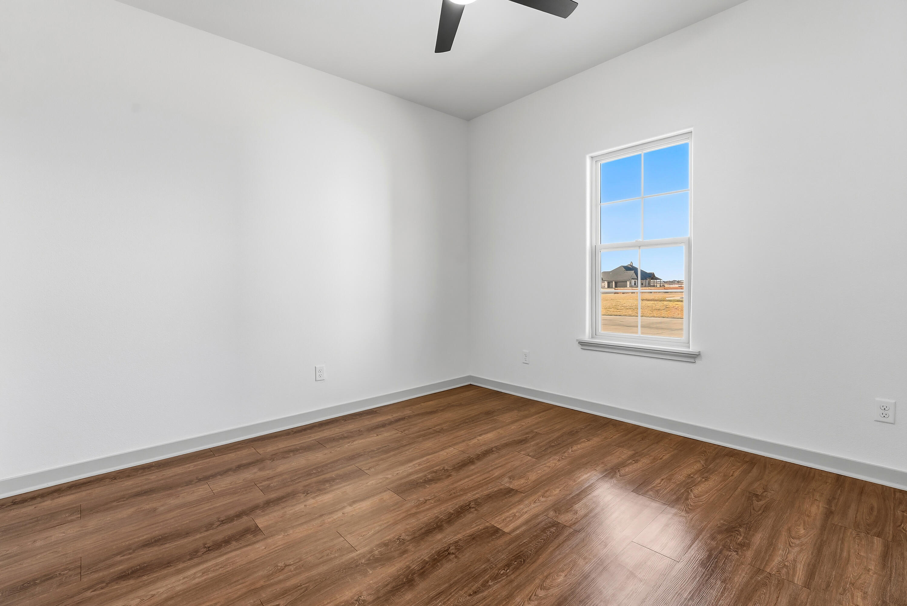 19215 County Road 2240 Lubbock, TX 79423 - Photo 26 of 36 an empty room with wooden floor and windows