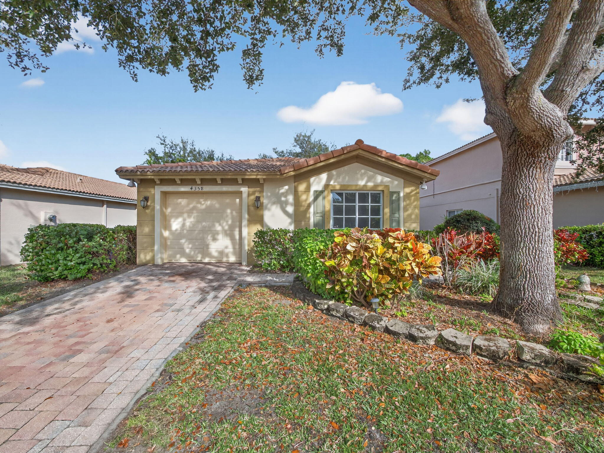 4358 Southeast Graham Drive Stuart, FL 34997 - Photo 3 of 34 a view of a house with a small yard and a large tree