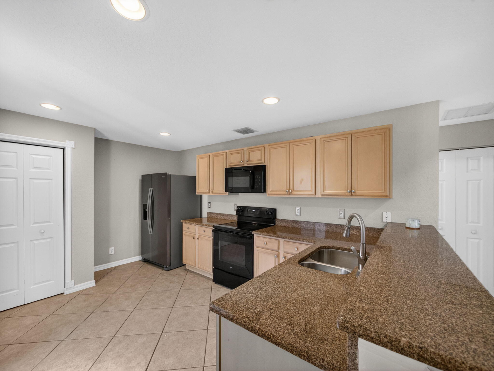 4358 Southeast Graham Drive Stuart, FL 34997 - Photo 10 of 34 a kitchen with stainless steel appliances granite countertop a refrigerator sink and stove