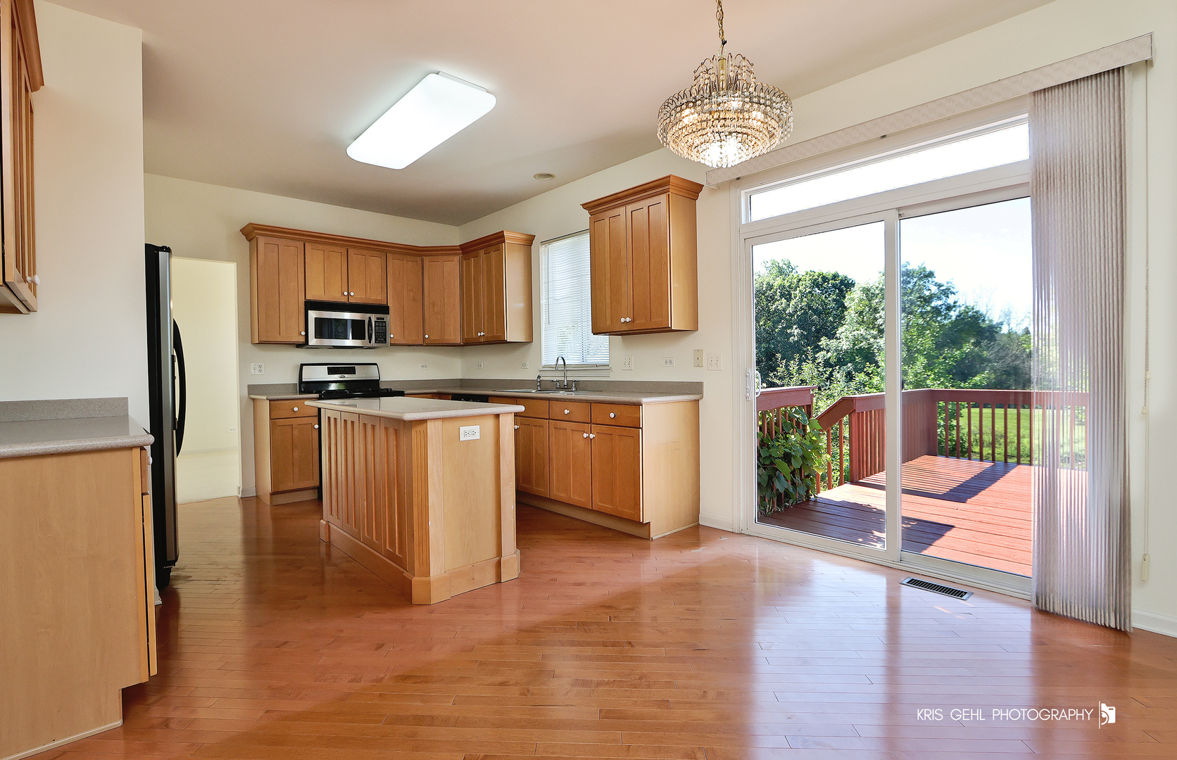 25619 West Bluestem Road Round Lake, IL 60073 - Photo 4 of 33 a kitchen with stainless steel appliances granite countertop a stove top oven a sink dishwasher a dining table and chairs with wooden floor