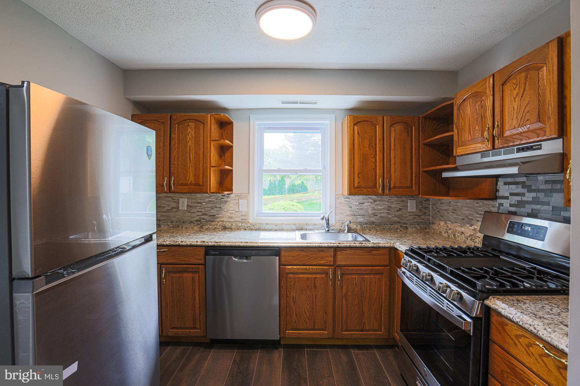 11908 Tarragon Road, Unit G Reisterstown, MD 21136 - Photo 12 of 22 Modern kitchen with warm wood accents.