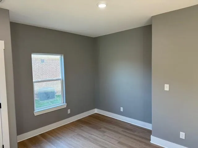 a kitchen with granite countertop white cabinets appliances a window and a sink
