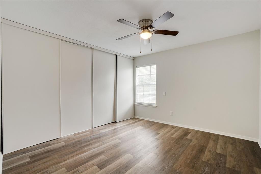 1105 UTA Boulevard, Unit 102 Arlington, TX 76013 - Photo 7 of 10 an empty room with wooden floor fan and windows