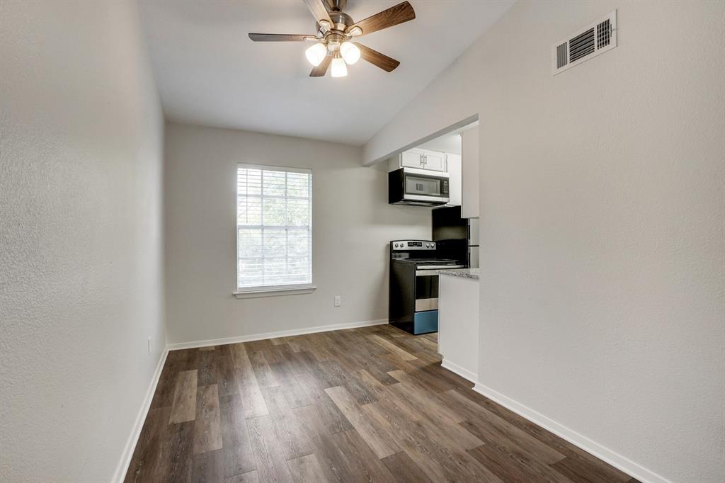 1105 UTA Boulevard, Unit 102 Arlington, TX 76013 - Photo 8 of 10 a view of a kitchen with wooden floor a ceiling fan and windows