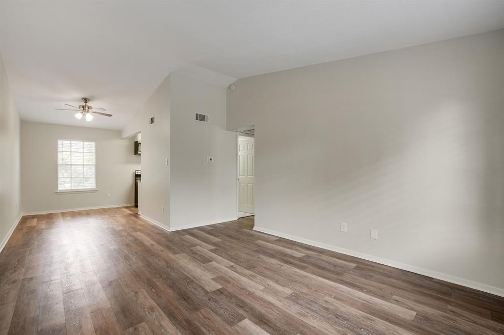 1105 UTA Boulevard, Unit 102 Arlington, TX 76013 - Photo 9 of 10 a view of an empty room with wooden floor and a window