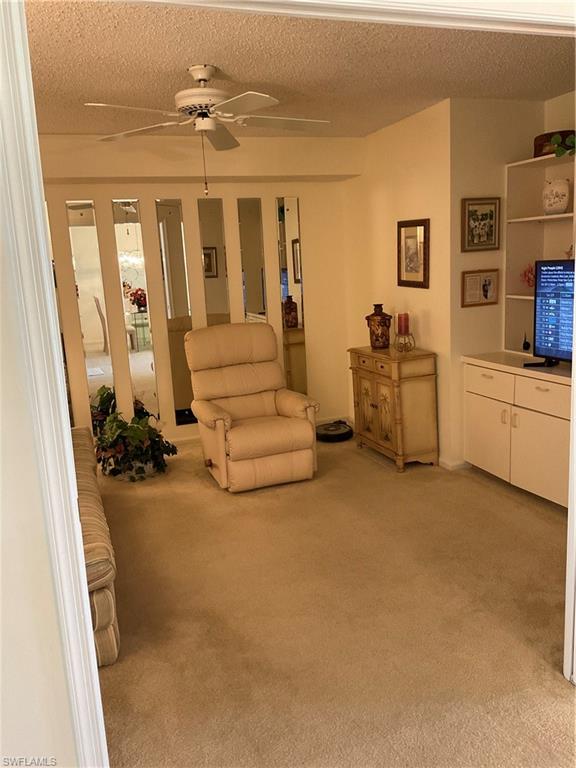 6780 Dennis Circle, Unit M103 Naples, FL 34104 - Photo 12 of 23 a living room with furniture and a chandelier