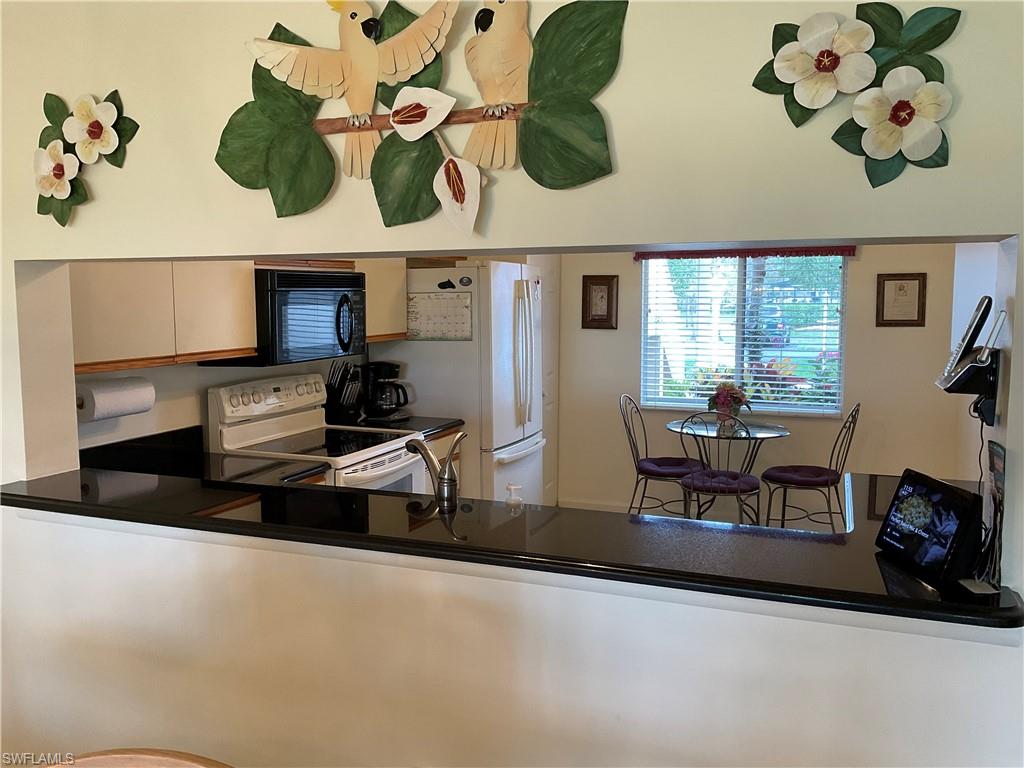 6780 Dennis Circle, Unit M103 Naples, FL 34104 - Photo 13 of 23 a living room filled with furniture