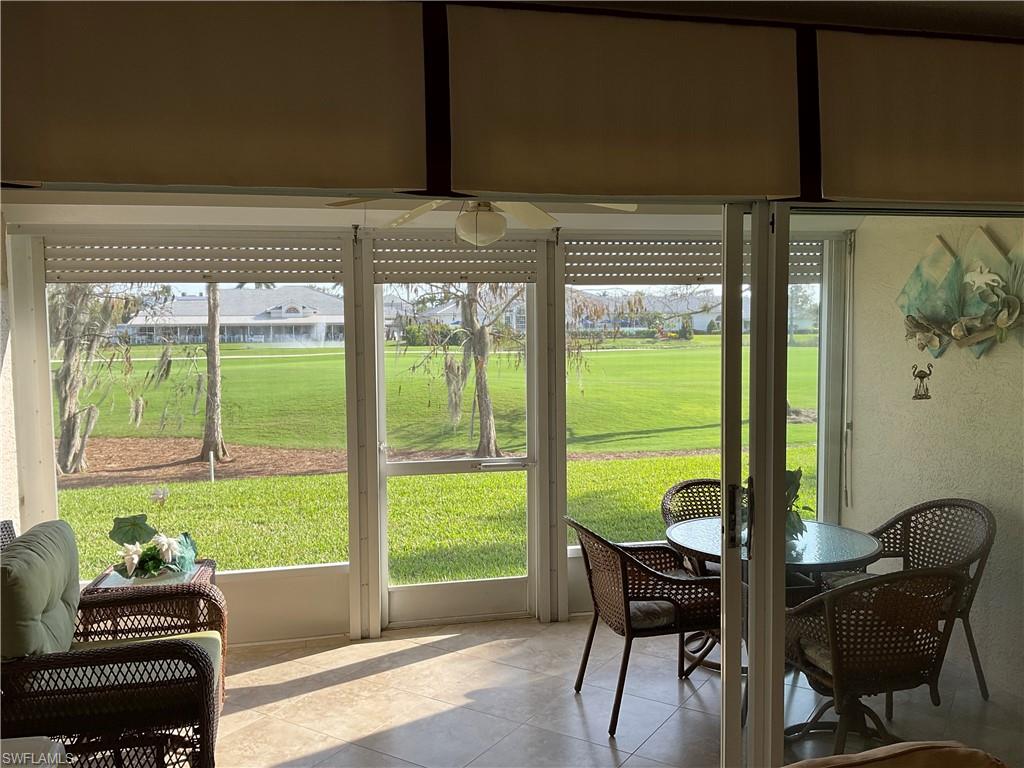 6780 Dennis Circle, Unit M103 Naples, FL 34104 - Photo 16 of 23 a living room with furniture and a floor to ceiling window