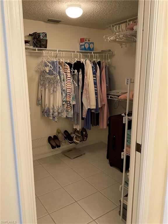 6780 Dennis Circle, Unit M103 Naples, FL 34104 - Photo 9 of 23 a view of walk in closet with clothes and shoes