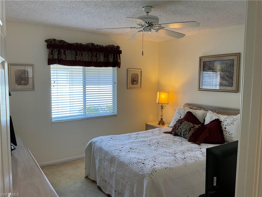 6780 Dennis Circle, Unit M103 Naples, FL 34104 - Photo 10 of 23 a bedroom with a bed and a window
