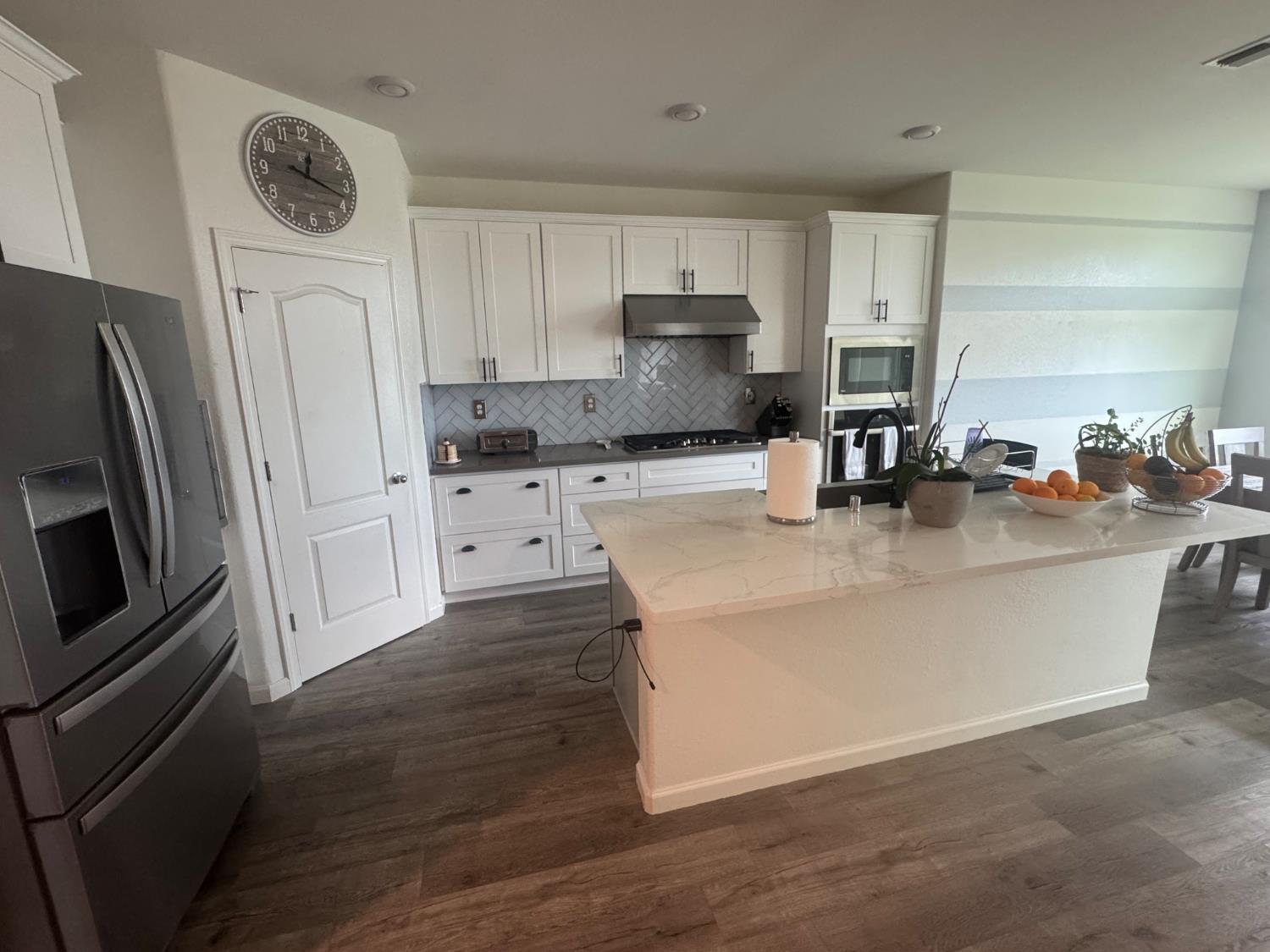 9475 Pasaje Place Elk Grove, CA 95624 - Photo 20 of 26 a kitchen with stainless steel appliances a refrigerator a sink a stove a microwave and cabinets