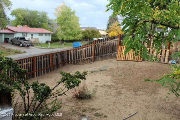 a view of a garden with wooden fence