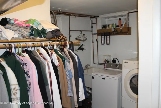 a view of walk in closet with clothes and shoes