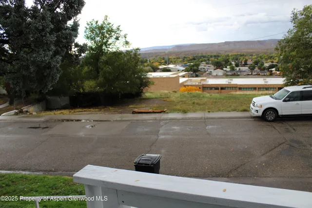 a view of street with a cars park side of road