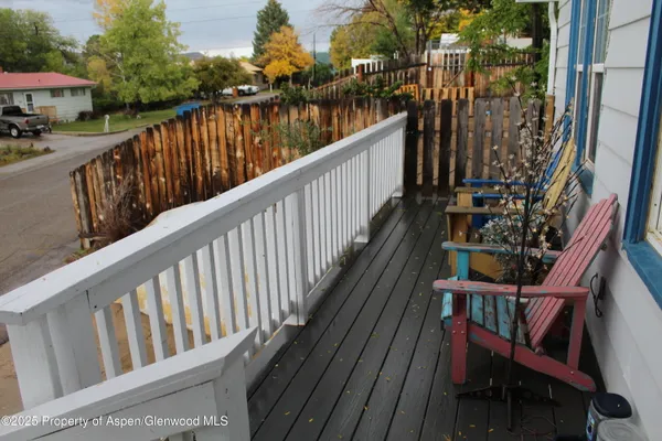 a view of balcony with wooden floor and fence