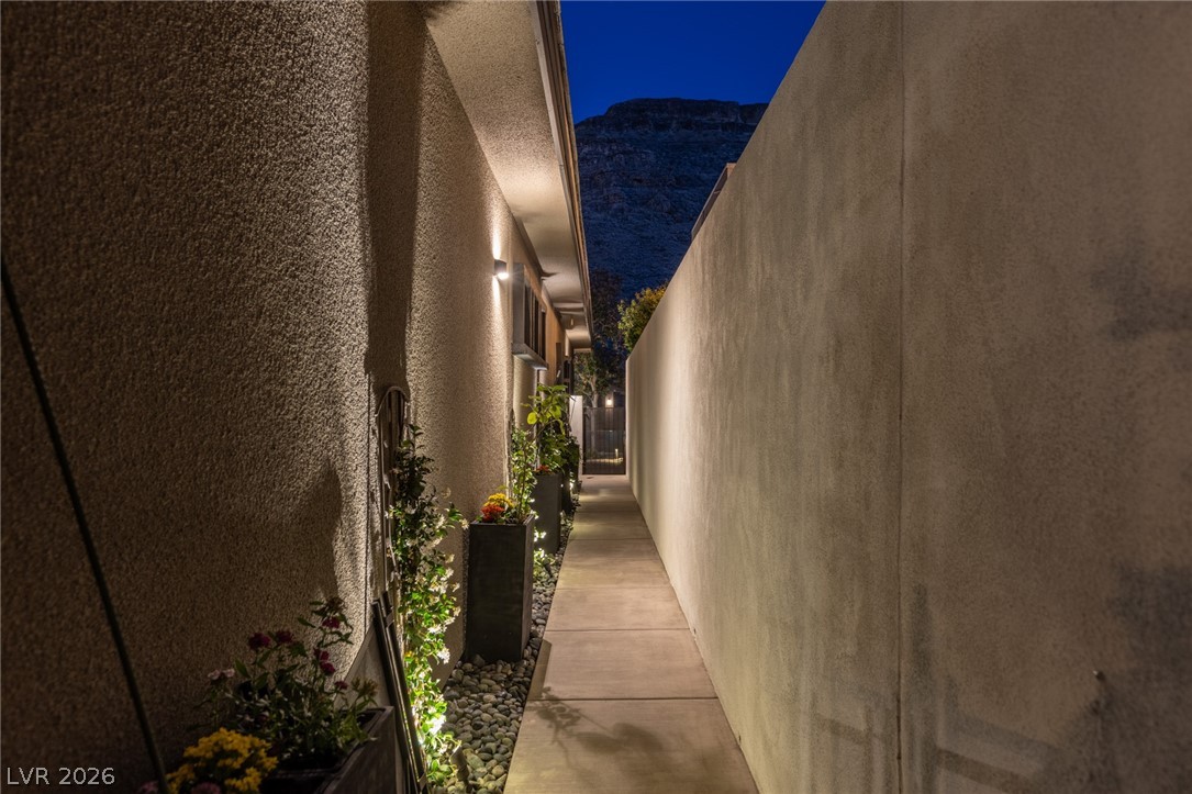 10118 Copper Edge Road Las Vegas, NV 89148 - Photo 37 of 48 An inviting pathway, expertly lit, guides you along a beautifully landscaped private yard towards distant mountain vistas.