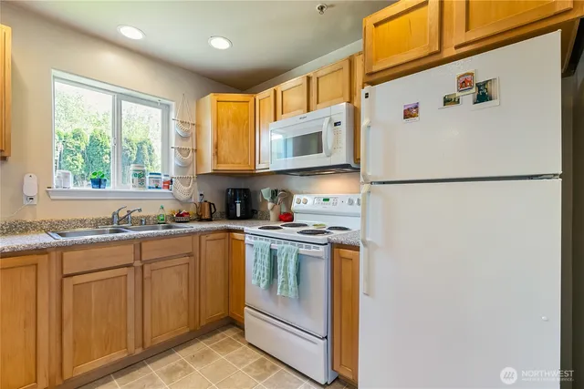 a kitchen with stainless steel appliances granite countertop a refrigerator sink stove and microwave