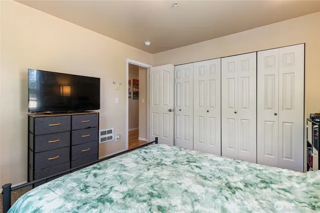a bedroom with a bed and a flat screen tv
