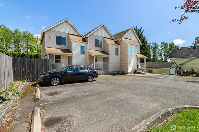 a car parked in front of a white house
