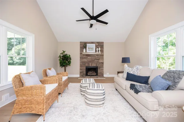 a living room with furniture a fireplace and a large window