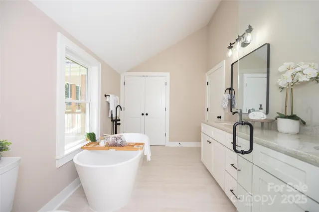 a spacious bathroom with a tub sink and mirror