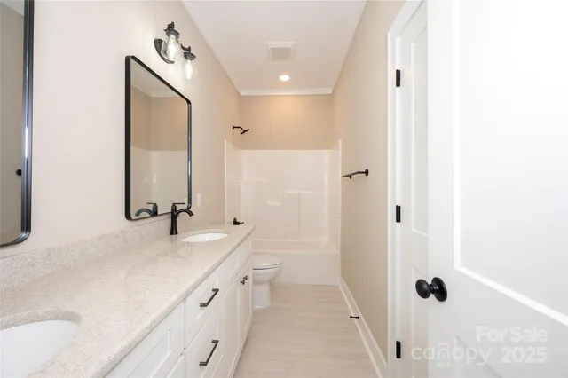 a bathroom with a double vanity sink a mirror and a bathtub