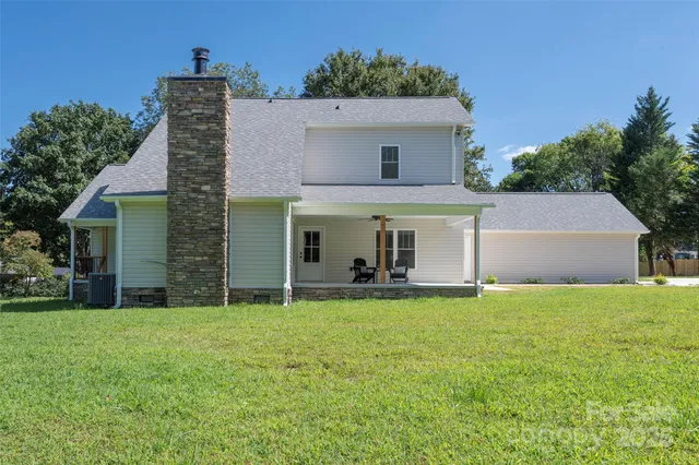a front view of house with yard and trees in the background