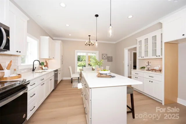 a large white kitchen with sink and white cabinets