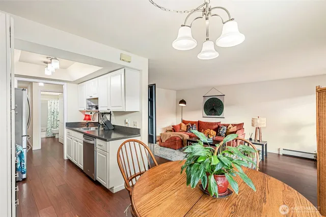 a kitchen with stainless steel appliances kitchen island granite countertop a table and chairs in it