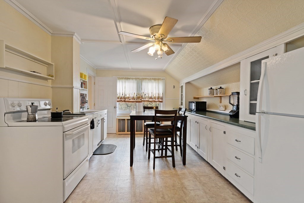 57 Chadwick Road Haverhill, MA 01835 - Photo 17 of 25 a kitchen with stainless steel appliances a white table chairs and a refrigerator