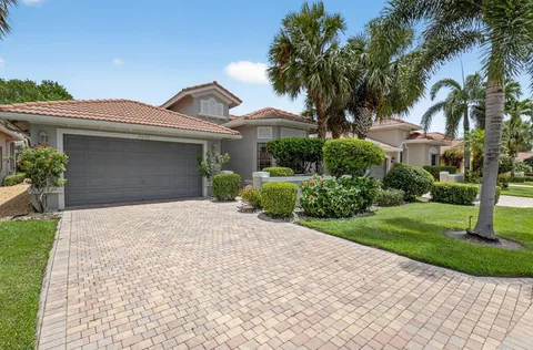 a front view of a house with a yard and potted plants