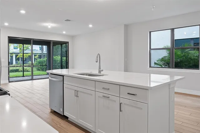 a kitchen with sink and large window