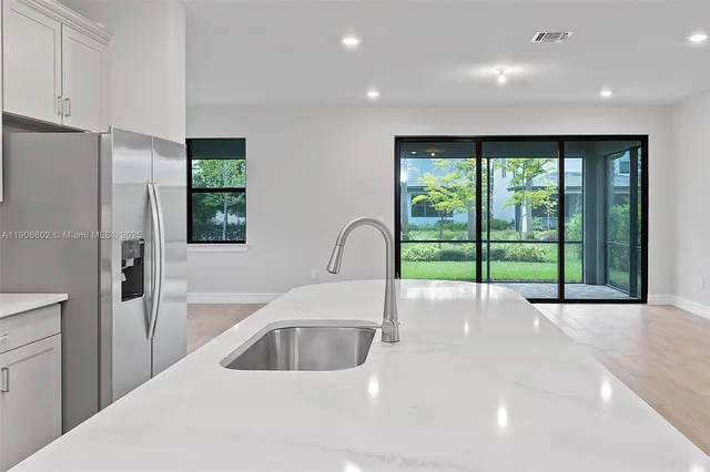 a view of a kitchen with a sink and large window