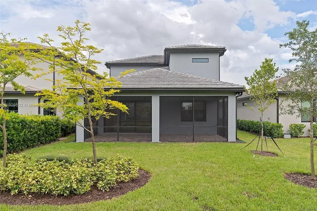a house with a big yard and potted plants