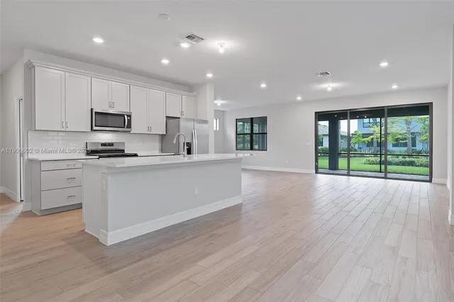 a kitchen with stainless steel appliances granite countertop a stove a sink and a microwave