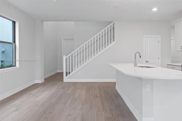 a view of a hallway with wooden floor and staircase