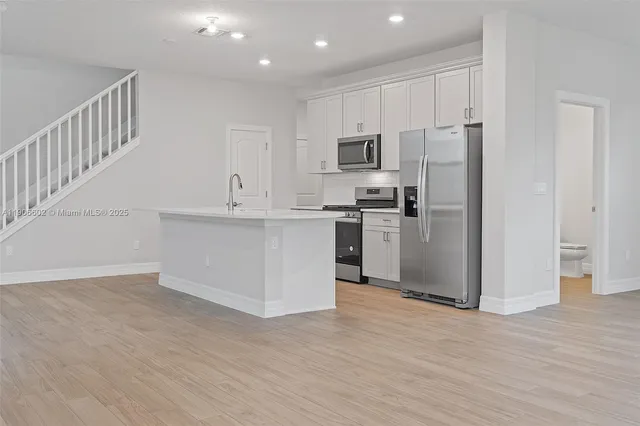 a kitchen with stainless steel appliances a refrigerator and a stove top oven