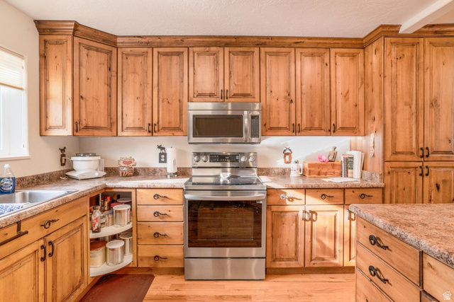 48 South Sage Road Pine Valley, UT 84781 - Photo 19 of 61 Kitchen featuring extensive wood-finish cabinetry, stainless steel appliances, and durable laminate countertops