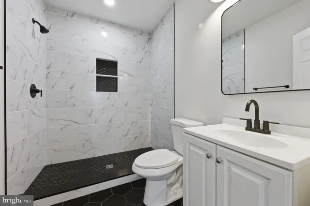 a bathroom with a sink a toilet and a mirror