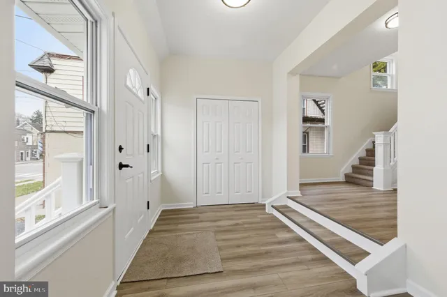 a view of a hallway with wooden floor and staircase