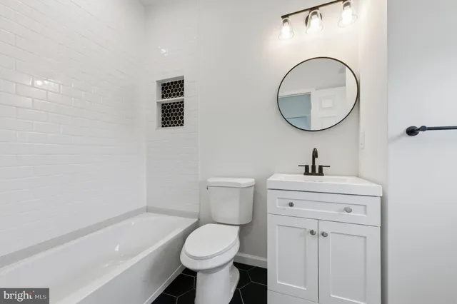 a bathroom with a toilet sink and mirror