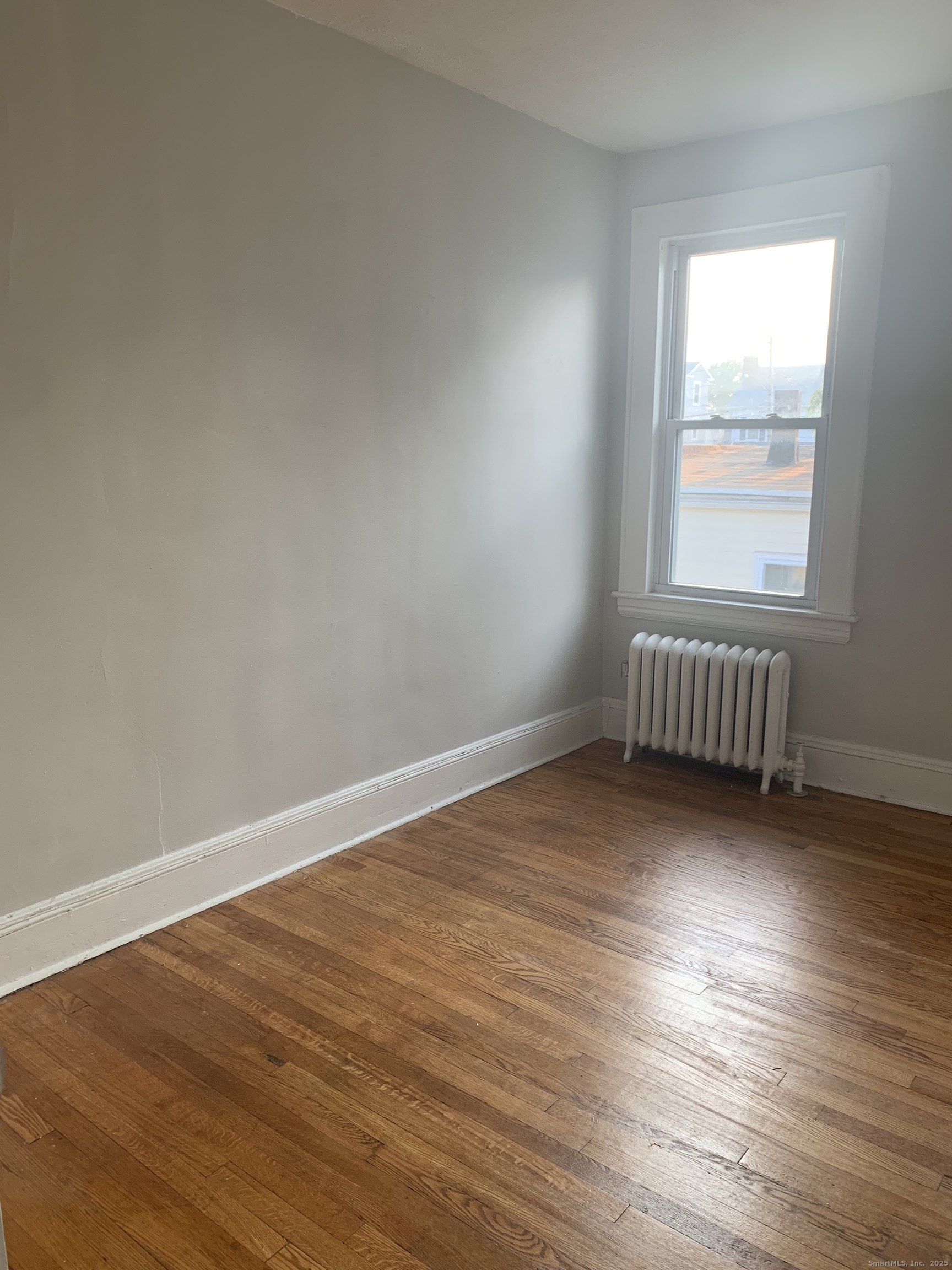 96 Seaview Terrace Bridgeport, CT 06605 - Photo 6 of 23 an empty room with wooden floor and windows