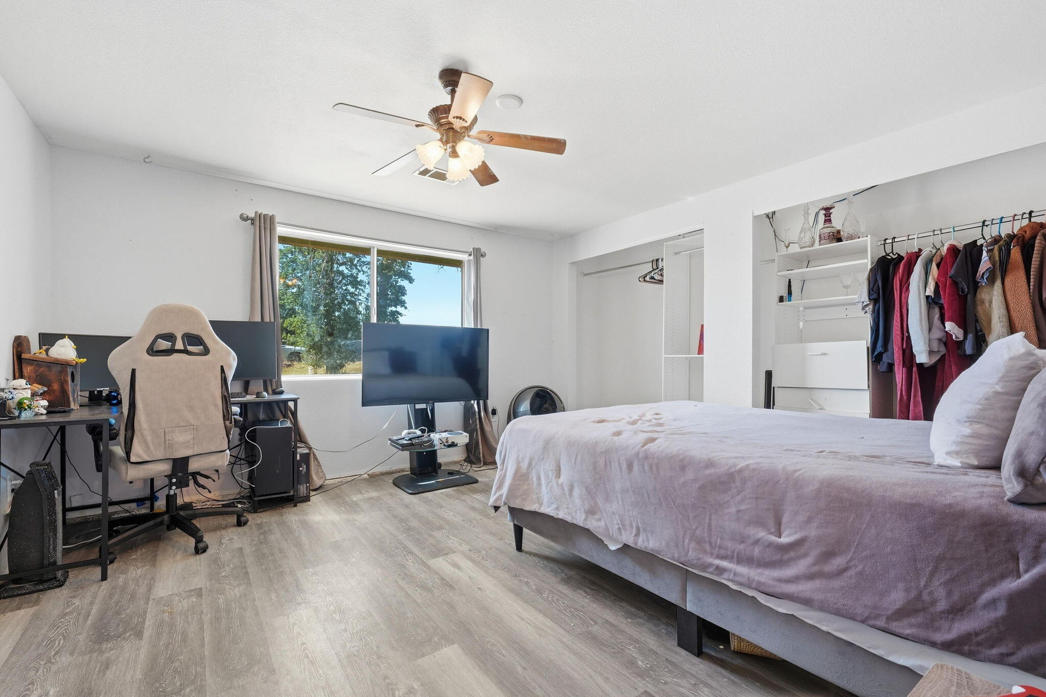 22189 Old Alturas Road Redding, CA 96003 - Photo 20 of 70 a bedroom with a bed a desk and dresser with wooden floor